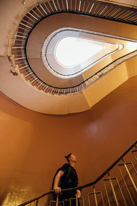 Low angle view of man standing on staircase in building