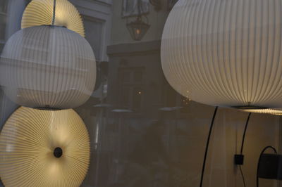 Low angle view of illuminated lighting equipment hanging from ceiling