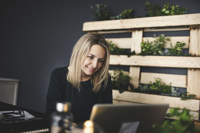 Young woman using phone while sitting on table