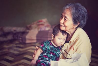 Grandmother with baby girl sitting at home