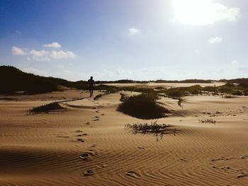 Man walking on sand dune in desert