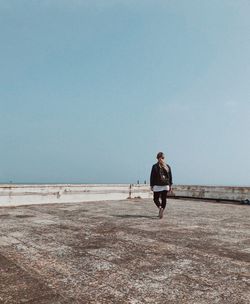 Full length of man running on shore against clear sky