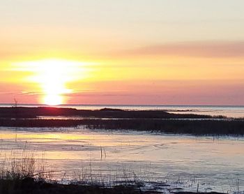 Scenic view of sea against dramatic sky during sunset