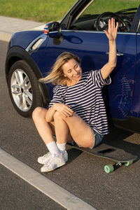 Full length of woman sitting on road