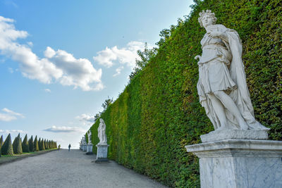 Statue amidst plants against sky