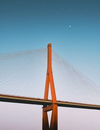 Low angle view of suspension bridge against clear blue sky