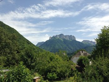 Scenic view of trees and mountains against sky