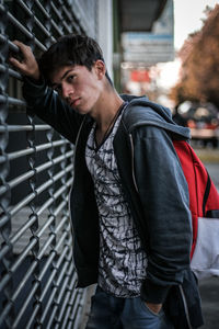 Portrait of young man standing by built structure