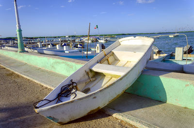 Boats moored on sea against blue sky