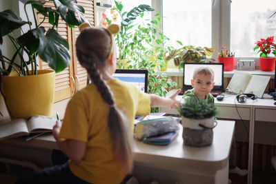 Woman using digital tablet while sitting on table