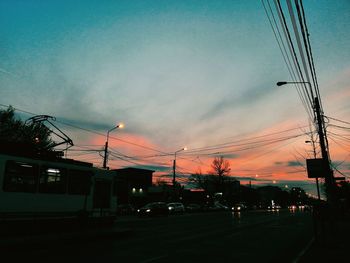 Silhouette street against sky at sunset