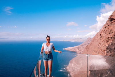 Rear view of woman looking at sea against sky