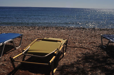 Chairs on beach against sky