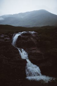 Scenic view of waterfall against sky