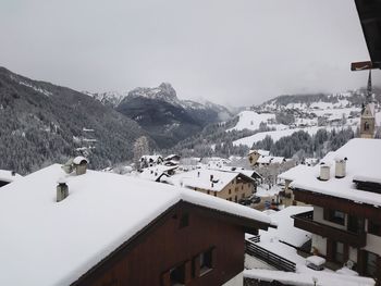 Houses and snowcapped mountains against sky