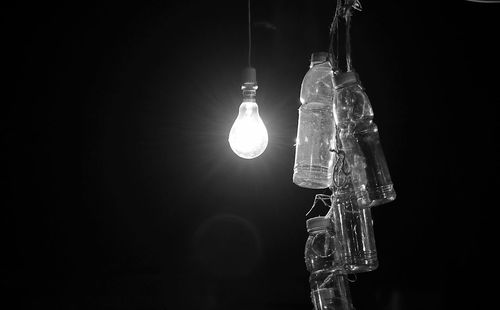 Close-up of illuminated light bulb against black background