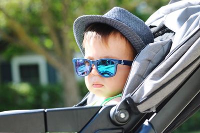 Baby boy wearing sunglasses in stroller