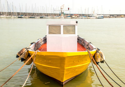 Boat moored at harbor against sky