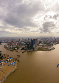 High angle view of buildings by river against sky