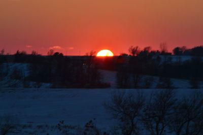 Scenic view of snow covered landscape at sunset