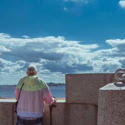 Woman standing against cloudy sky