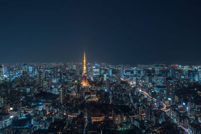 Illuminated cityscape against sky at night