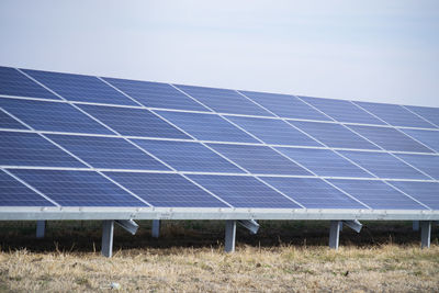 Solar panels on field against clear sky