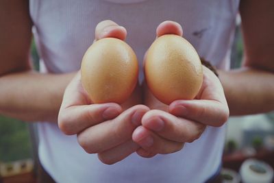 Midsection of man holding eggs