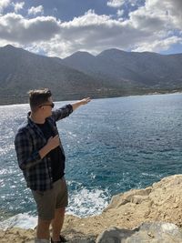 Man standing by sea against sky