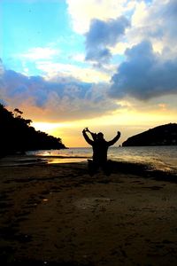 Silhouette of people on beach at sunset