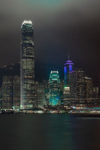 Illuminated buildings in city against sky at night