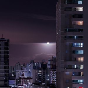 Illuminated buildings against sky at night