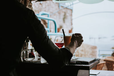 Midsection of man holding drink