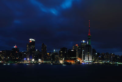 Illuminated buildings in city against sky at night