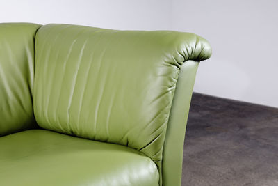 Close-up of chair on sofa against wall at home