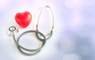 High angle view of heart shape model and stethoscope on table