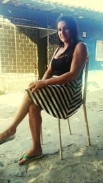 Portrait of young woman sitting on chair