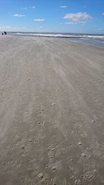 View of calm beach against blue sky