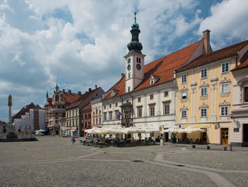 Buildings in city against cloudy sky