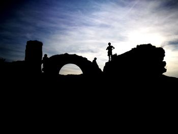 Low angle view of silhouette men against sky during sunset