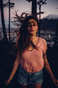 Portrait of woman standing against cityscape