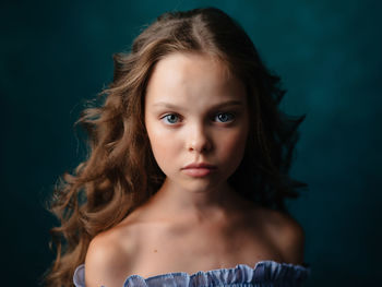 Portrait of girl against green background