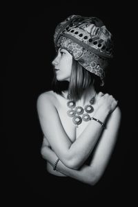 Close-up of young woman against black background