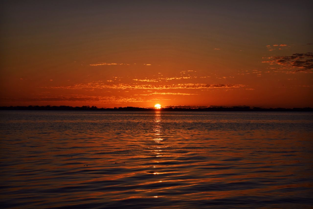 sunset, water, scenics, waterfront, tranquil scene, beauty in nature, sea, tranquility, orange color, sun, sky, idyllic, rippled, nature, reflection, horizon over water, outdoors, silhouette, sunlight, no people