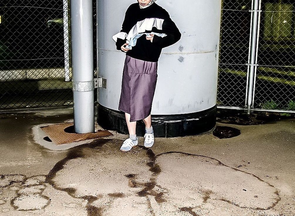 REAR VIEW OF WOMAN STANDING ON GROUND