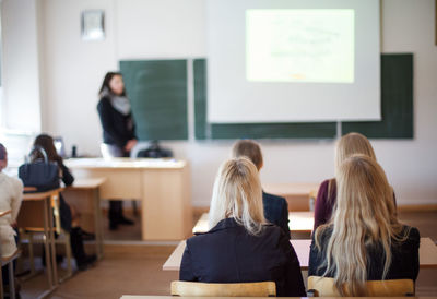 Rear view of students sitting in classroom