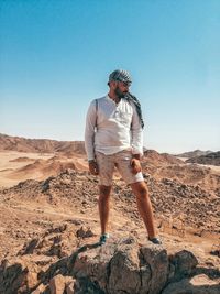 Midsection of man standing on land against clear sky