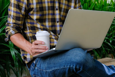 Midsection of man using mobile phone