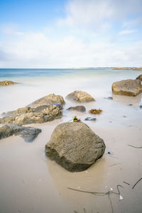 Rocks on beach against sky