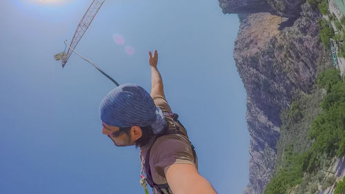 Low angle view of woman holding mountain against sky